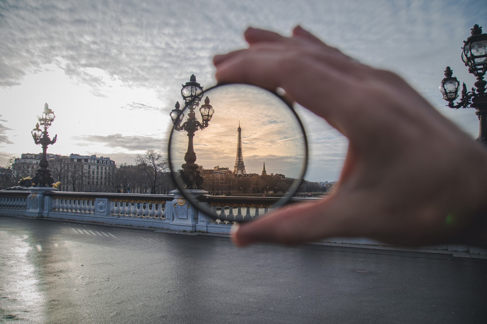 hand holding up polarising lens in front of Eiffel tower