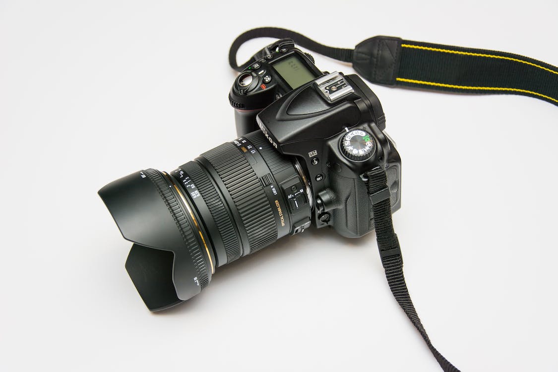 DSLR camera and strap on white background