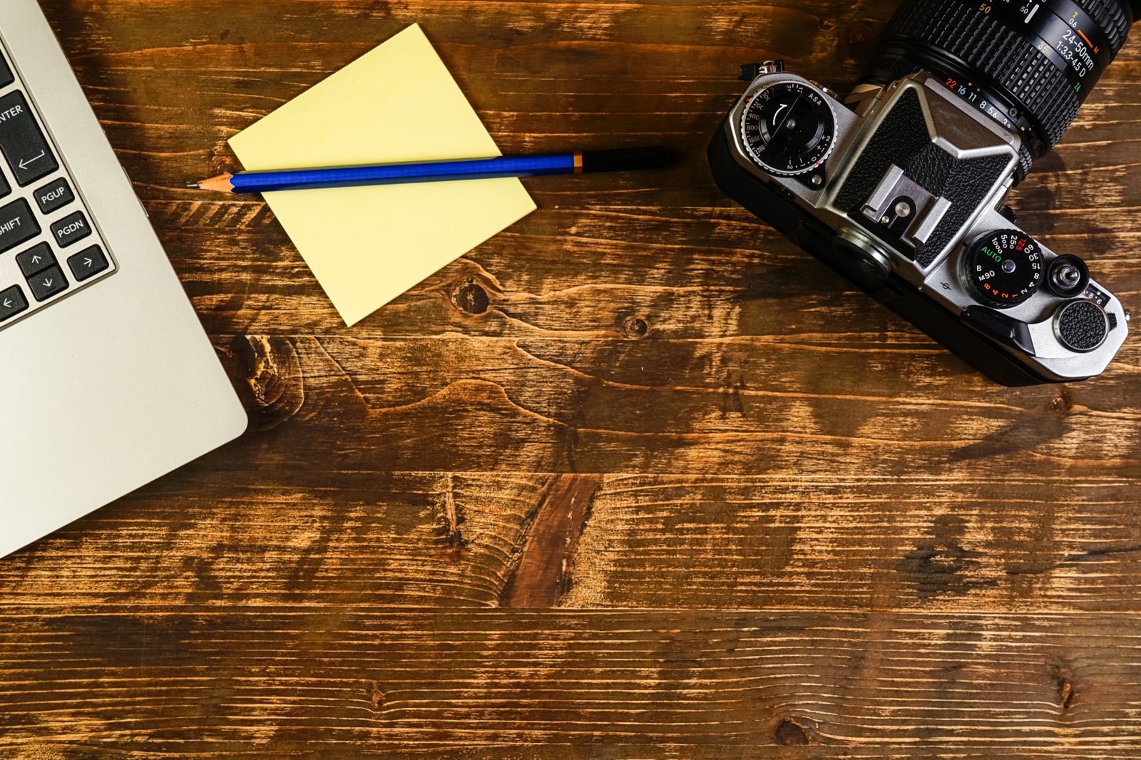 overhead view of camera, post-it notes, and a macbook