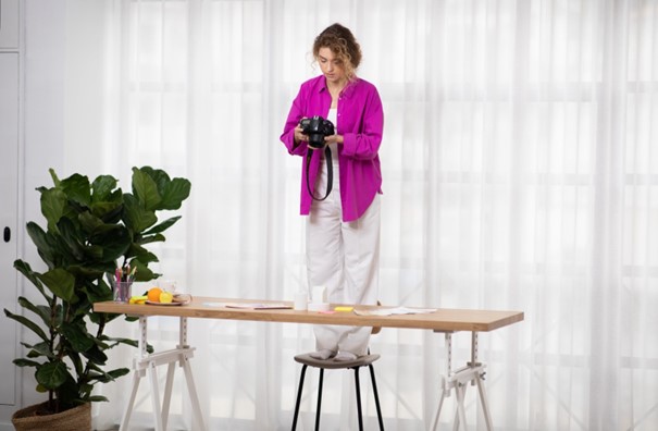 woman at home taking overhead photo of objects on a table