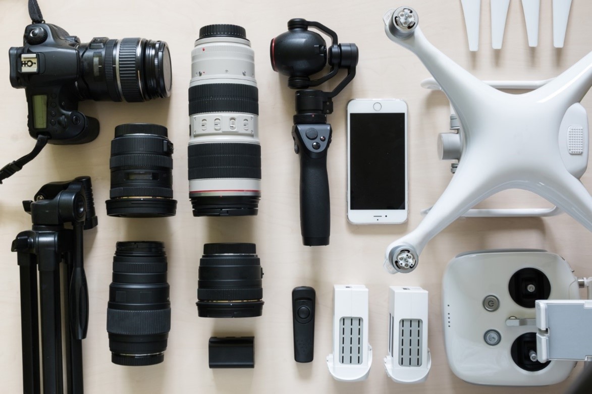 overhead view of camera accessories including lenses, a tripod, and a drone